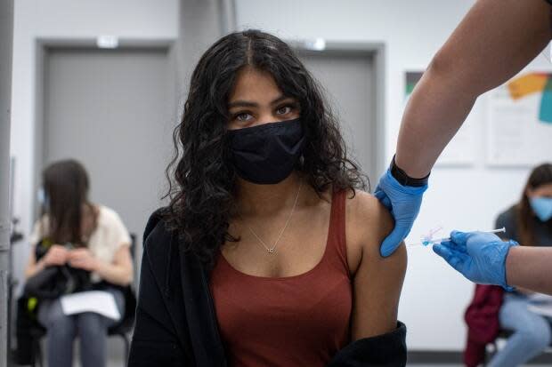 Menusha Manokumar, 20, gets her first dose of a COVID-19 vaccine at a pop-up clinic at Yorkgate Mall. Similar clinics are the only current option for adults aged 18 to 50 in hot-spot neighbourhoods. (Evan Mitsui/CBC - image credit)