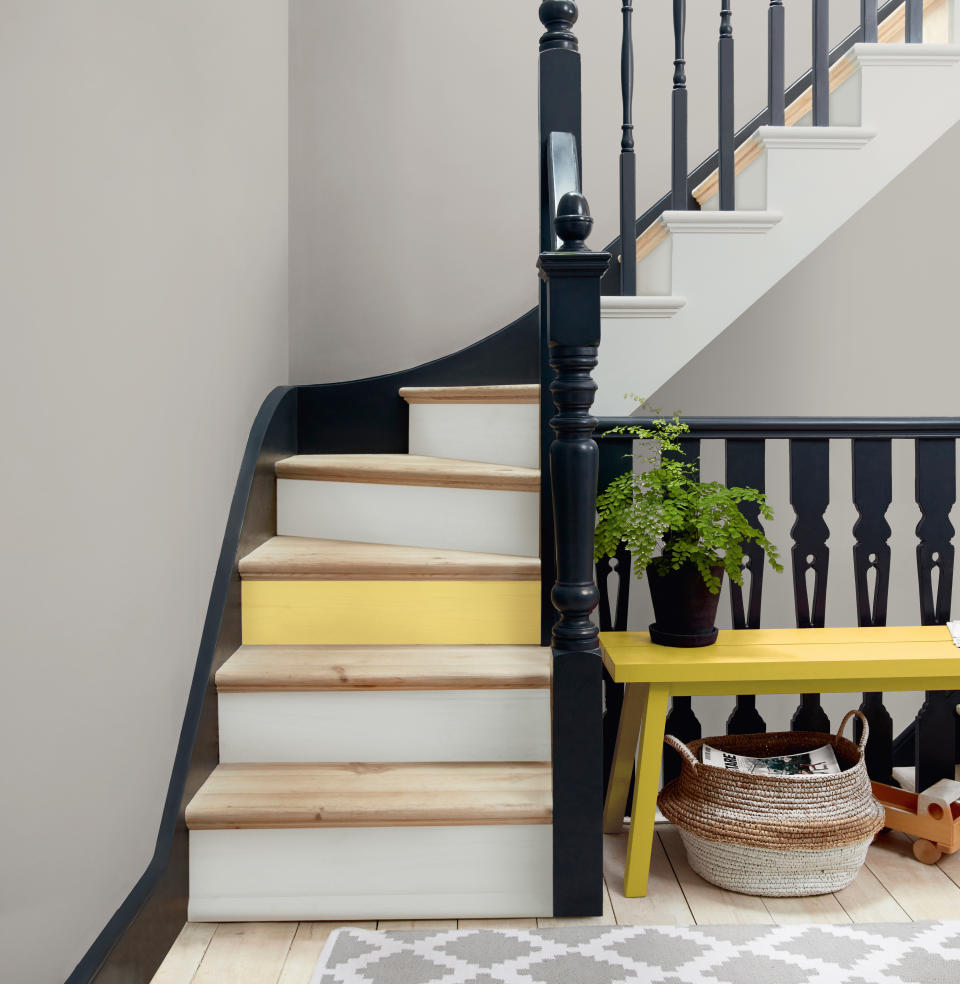 <p> Clever stair paint ideas can ensure even a relatively compact staircase can pack a decorative punch. This design teams pale wood treads with the classic combination of black &#x2013; for spindles, posts, handrail, and wall stringer &#x2013; and a soft white for the risers. But an accent of gentle yellow repeating that of the hall bench for the riser before the flight turns gives the design bags of personality. </p>