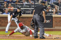 Philadelphia Phillies' Didi Gregorius (18) slides into home to score on a sacrifice fly by Matt Vierling during the seventh inning of the team's baseball game against the New York Mets, Friday, Sept. 17, 2021, in New York. (AP Photo/Mary Altaffer)