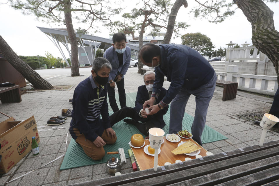 North Korean refugee Jo Kyeong-hyeon, second from right, and his family members offer wine to respect their ancestors in North Korea to celebrate the Chuseok, the Korean version of Thanksgiving Day, at Imjingak Pavilion in Paju, near the border with North Korea, South Korea, Thursday, Oct. 1, 2020. The government has discouraged people from visiting their hometowns for the Chuseok holiday amid concerns about the spread of the coronavirus. (AP Photo/Ahn Young-joon)