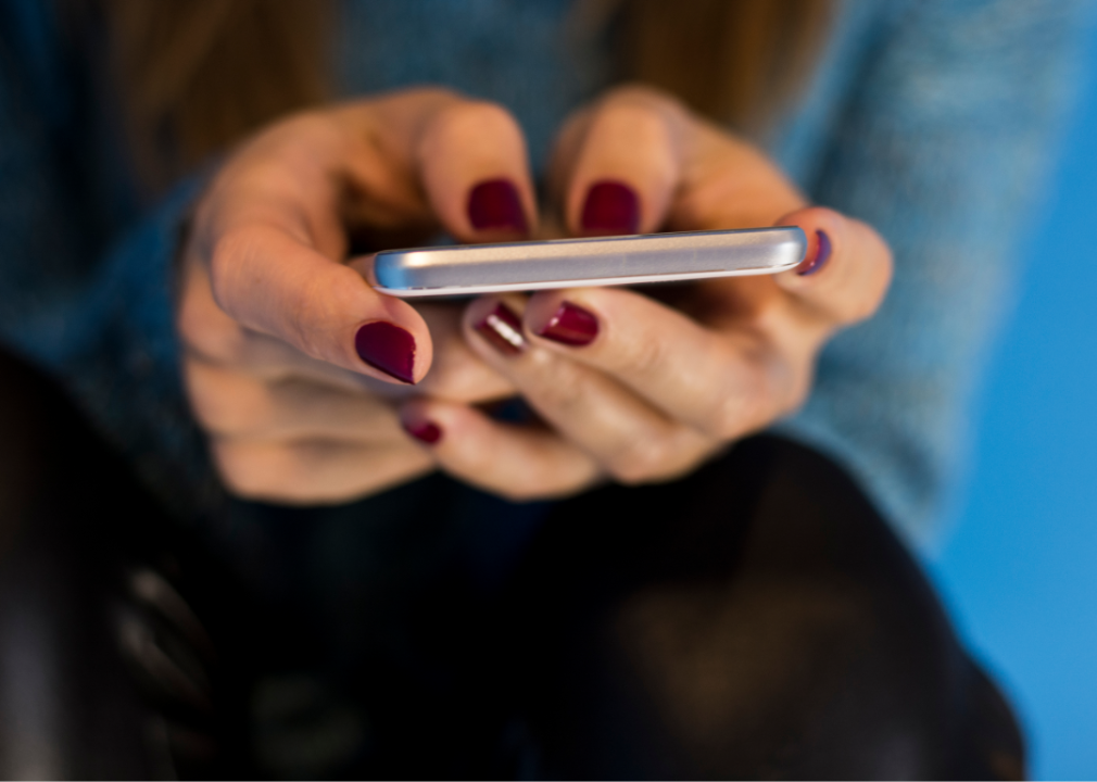 A cellphone being operated by two hands.