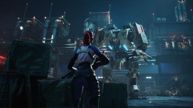 A person with a gun hides behind some crates as a giant robot approaches. 