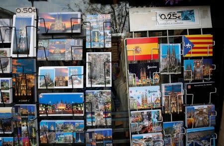 Postcards showing Spanish flag, an Estelada (Catalan separatist flag), Sagrada Familia and other Barcelonian tourist attractions are displayed at a souvenirs shop in Barcelona, Spain, December 12, 2018. REUTERS/Albert Gea