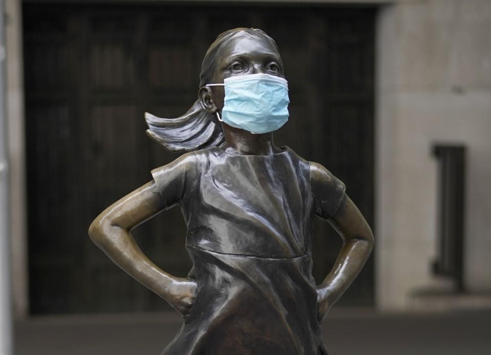 Fearless Girl, a bronze sculpture by Kristen Visbalthe, with a PPE mask on in front of the New York Stock Exchange in the Wall Street Financial District of Manhattan New York May 19, 2020. (Photo by TIMOTHY A. CLARY / AFP) / RESTRICTED TO EDITORIAL USE - MANDATORY MENTION OF THE ARTIST UPON PUBLICATION - TO ILLUSTRATE THE EVENT AS SPECIFIED IN THE CAPTION (Photo by TIMOTHY A. CLARY/AFP via Getty Images)