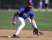 Seattle Seahawks quarterback Russell Wilson fields a ground ball at second while working out with the Texas Rangers during spring training baseball practice, Monday, March 3, 2014, in Surprise, Ariz. (AP Photo/Tony Gutierrez)