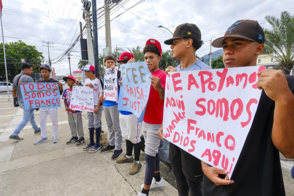Youth baseball players from the local team “Liga deportiva Antera Mota” show support for Tampa Bay Rays shortstop Wander Franco with posters that read in Spanish: “Free Franco,” and “We all are Franco.” outside the court where he arrived in Puerto Plata, Dominican Republic, Friday, Jan. 5, 2024. Dominican prosecutors on Wednesday accused Franco of commercial sexual exploitation and money laundering following allegations that he had a relationship with a minor whose mother also faces the same charges. (AP Photo/Ricardo Hernández)