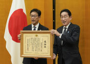 Japan's World Baseball Classic (WBC) team manager Hideki Kuriyama, left, receives a testimonial from Japanese Prime Minister Fumio Kishida at the latter's official residence in Tokyo, Japan, Thursday, March 23, 2023. Japan won over the U.S. at the WBC final Tuesday. (Kimimasa Mayama/Pool Photo via AP)