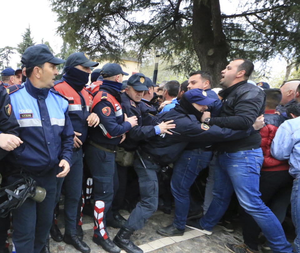 Protesters clash with police front of the Albanian parliament building in Tirana, on Thursday, March 28, 2019. Albanian opposition protesters have repeated attempts to enter the parliament by force in their protest asking for the government's resignation and an early election.(AP Photo/ Hektor Pustina)
