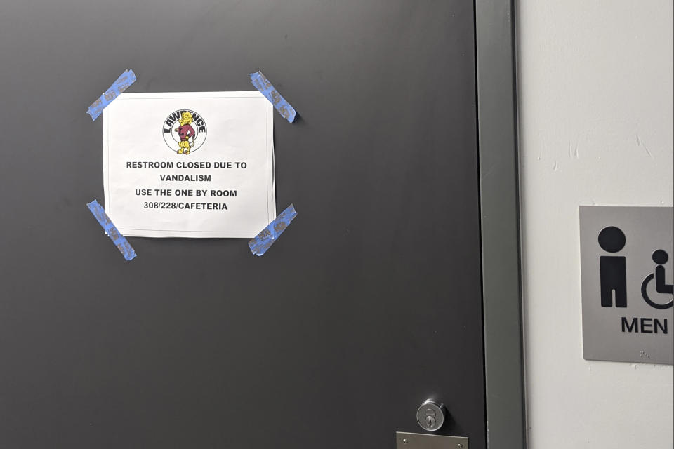 In this Friday, Sept. 17, 2021 courtesy of Cuyler Dunn shows a sign on a closed restroom at Lawrence High School in Lawernce, Kan. Students across the country are videoing themselves stealing soap dispensers, microscopes and even turf off stadium football fields and posting their heists on TikTok in a phenomenon dubbed "devious licks" that is bedeviling administrators and forcing them to shut down bathrooms. (Cuyler Dunn via AP)