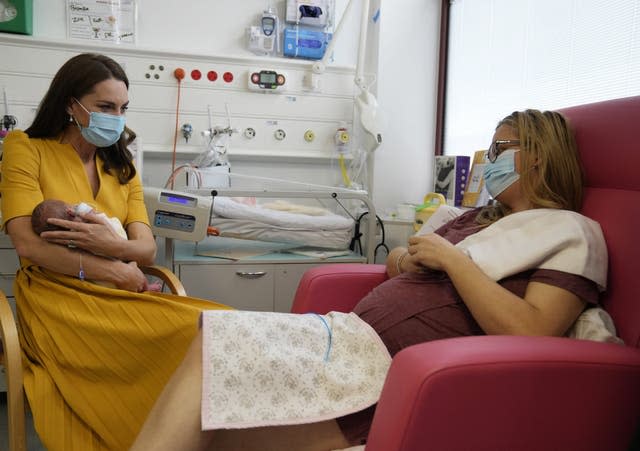 The Princess of Wales speaks to Sylvia Novak as she cradles Ms Novak’s daughter Bianca during a visit to the Royal Surrey County Hospital’s maternity unit in Guildford