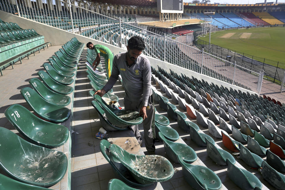 In this Monday, Feb. 17, 2020, photo, workers replace broken seats at Gaddafi stadium in preparation for upcoming Pakistan Super League, in Lahore, Pakistan. Security concerns stopped foreign cricketers from touring Pakistan four years ago when the country's premier domestic Twenty20 tournament was launched, forcing organizers to stage the event on neutral turf in the United Arab Emirates. When the 2020 edition of the PSL starts in Karachi on Thursday, Darren Sammy of the West Indies and Shane Watson of Australia will be among 36 foreign cricketers involved in the six franchises. (AP Photo/K.M. Chaudary)