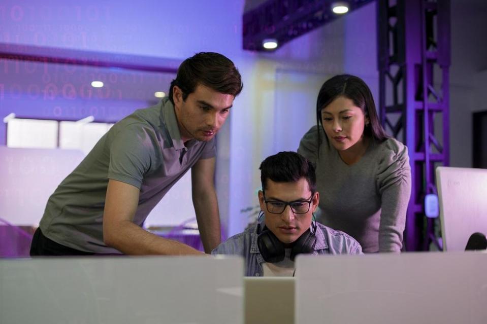 Jóvenes trabajando frente a un computador