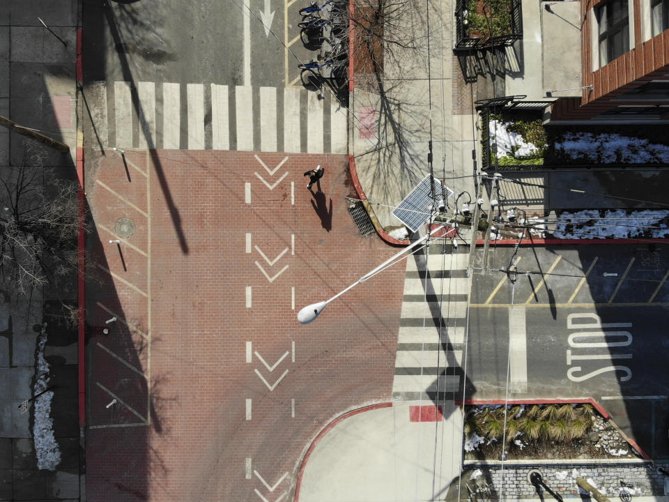 A pedestrian crosses the street at the intersection of Adams and 12th in Hoboken, N.J., Thursday, Feb. 22, 2024. This intersection has a number of pedestrian safety features, including planters as curb extenders, bottom right, high visibility markings and textured surfaces, all in an effort to increase pedestrian safety. (AP Photo/Seth Wenig)