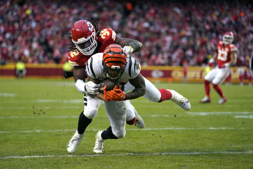 Cincinnati Bengals running back Joe Mixon scores as Kansas City Chiefs linebacker Nick Bolton (32) defends during the first half of an NFL football game Sunday, Dec. 31, 2023, in Kansas City, Mo. (AP Photo/Ed Zurga)