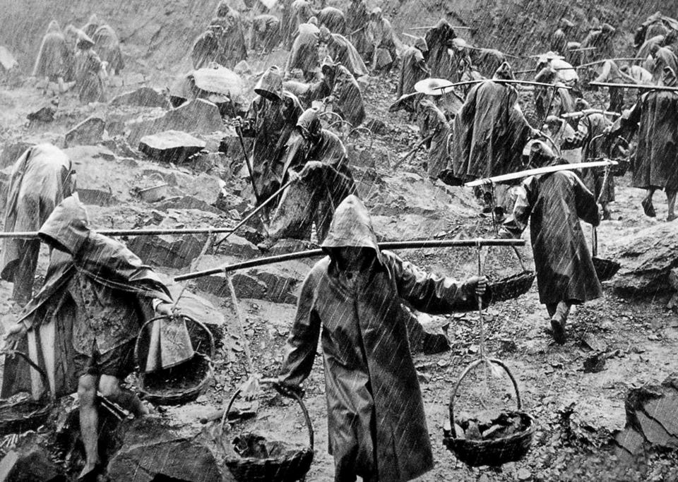 A team of workers labouring in a stone quarry in heavy rain during the 'Great Leap Forward' (1959 - 1961.)