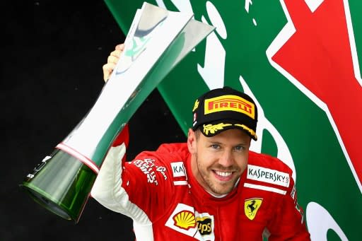 Ferrari's Sebastian Vettel celebrates on the podium with his trophy after winning the Canadian Formula One Grand Prix at Circuit Gilles Villeneuve