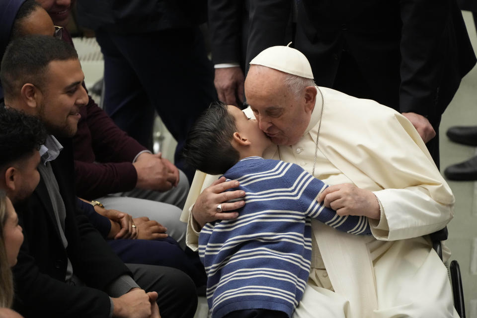 Pope Francis is hugged by a child during the weekly general audience at the Vatican, Wednesday, March 27, 2024. (AP Photo/Gregorio Borgia)