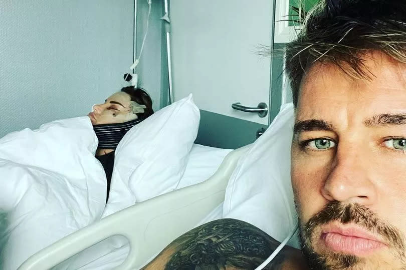 Carl Woods in a selfie with Katie Price seen in a hospital bed behind him