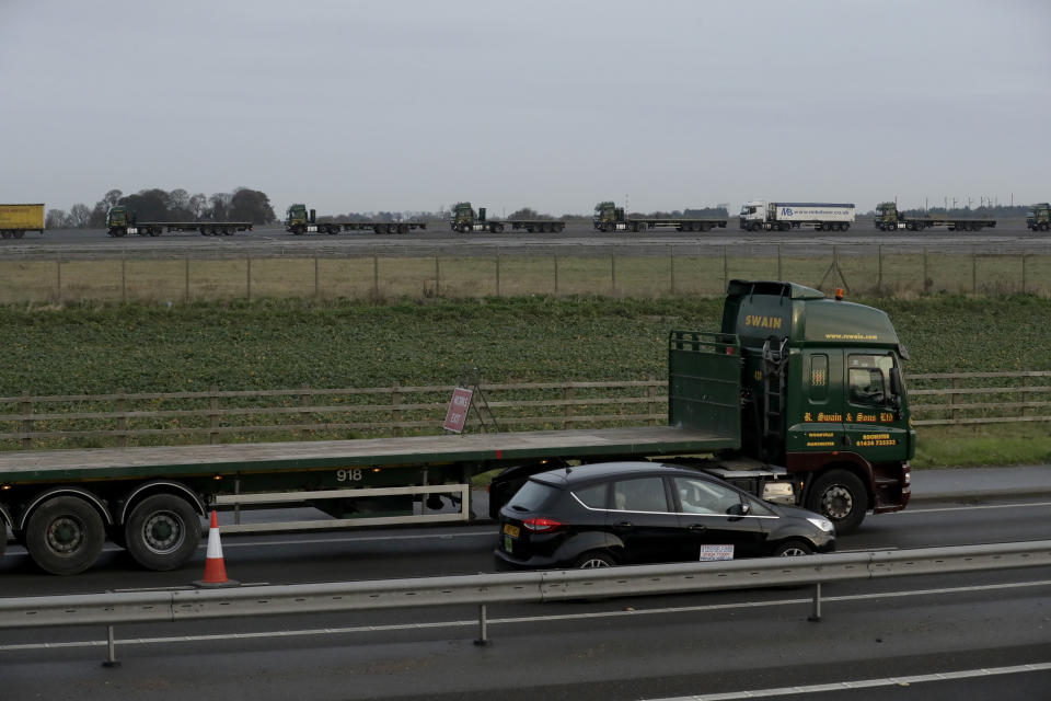 A truck in foreground and others in background forming part of some 150 trucks leaving Manston Airfield during a 'no-deal' Brexit test, to assess where 6,000 trucks could be parked at the former airfield near Ramsgate in south east England, Monday, Jan. 7, 2019. The derelict airfield at Manston could be used as part of a government plan to park trucks to alleviate expected congestion at the channel ports, about 25 miles (40 Km) from the airfield, caused by the reintroduction of customs checks on goods in the event of Britain making a no-deal withdrawal from the European Union at the end of March.(AP Photo/Matt Dunham)