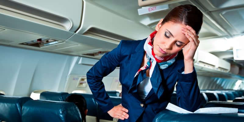 Junge Stewardess mit Kopfschmerzen in einem Flugzeug (Symbolbild).<span class="copyright">Getty Images/Izusek</span>