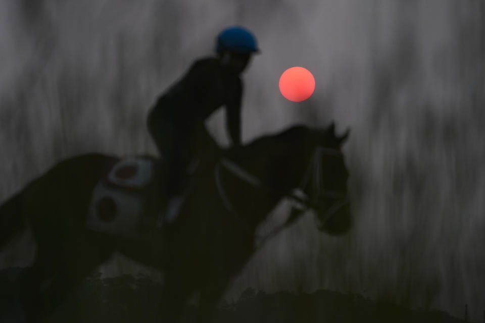 Haze from northern wildfires obscures the rising sun as horses train ahead of the Belmont Stakes horse race, Wednesday, June 7, 2023, at Belmont Park in Elmont, N.Y. (AP Photo/John Minchillo)