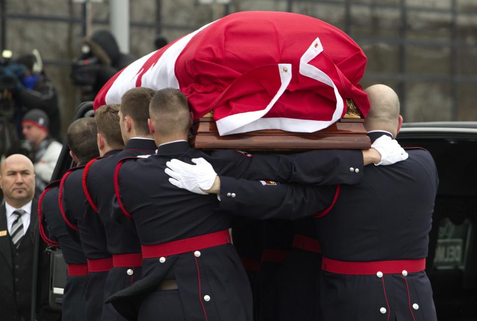 The casket of police constable John Zivcic is carried by honor guard into the public memorial in Toronto