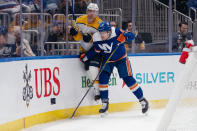 New York Islanders defenseman Ryan Pulock (6) checks Nashville Predators left wing Anthony Beauvillier during the first period of an NHL hockey game in Elmont, N.Y., Saturday, April 6, 2024. (AP Photo/Peter K. Afriyie)