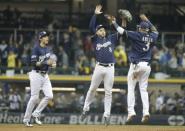 Oct 12, 2018; Milwaukee, WI, USA; Milwaukee Brewers right fielder Christian Yelich (22) and left fielder Ryan Braun (8) and shortstop Orlando Arcia (3) celebrate after defeating the Los Angeles Dodgers in game one of the 2018 NLCS playoff baseball series at Miller Park. Mandatory Credit: Jon Durr-USA TODAY Sports