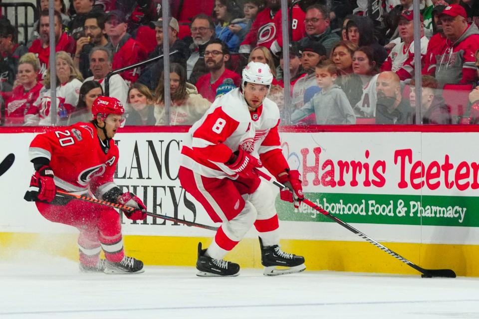 Red Wings defenseman Ben Chiarot controls the puck against Hurricanes center Sebastian Aho during the first period on Tuesday, April 11, 2023, in Raleigh, North Carolina.