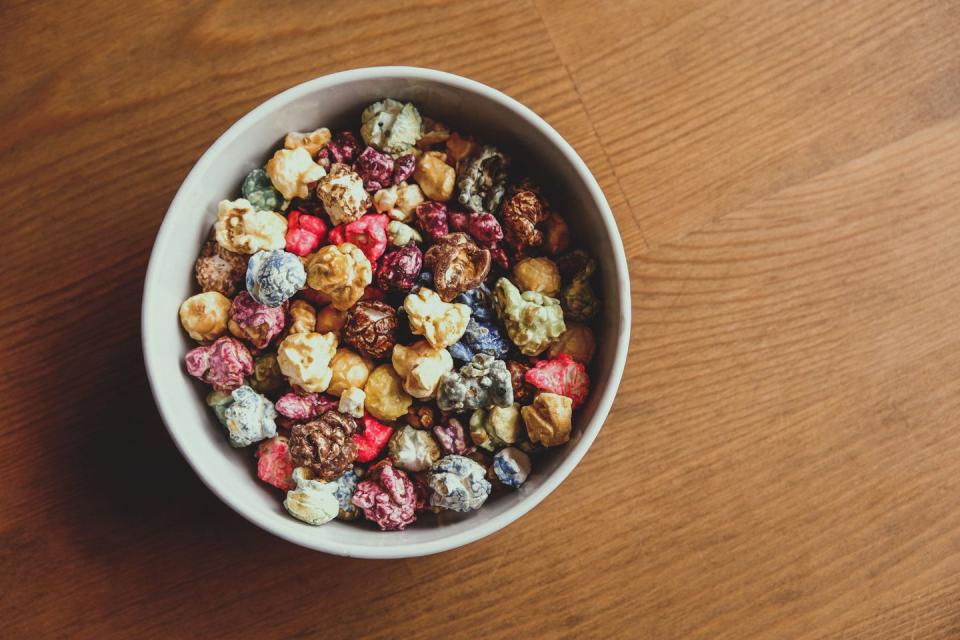 multicolored kettle popcorn on wooden background soft focus