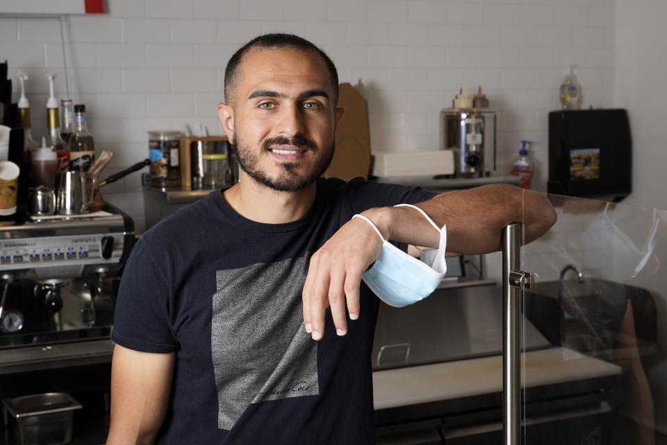 New U.S. citizen Jad "Jay" Jawad, owner of the Crepe House Cafe, who came to the U.S. as a refugee from war-torn Iraq, poses for a picture in his cafe on Friday, Sept. 4, 2020, in Phoenix. He said that during presidential elections in his native country, Saddam Hussein was the only candidate on the ballot and the only real option was "yes," because a "no" vote could get you jailed or worse. Now, he said he is looking to voting freely in his first U.S. presidential election this fall. (AP Photo/Ross D. Franklin)