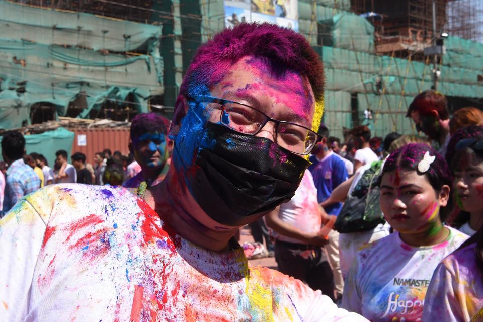 A tourist wearing a facemask amid fears of the spread of COVID-19 novel coronavirus, poses as he celebrates Holi, the spring festival of colours, on March 9, 2020. - Holi is observed at the end of the winter season on the last full moon of the lunar month. (Photo by PRAKASH MATHEMA / AFP) (Photo by PRAKASH MATHEMA/AFP via Getty Images)