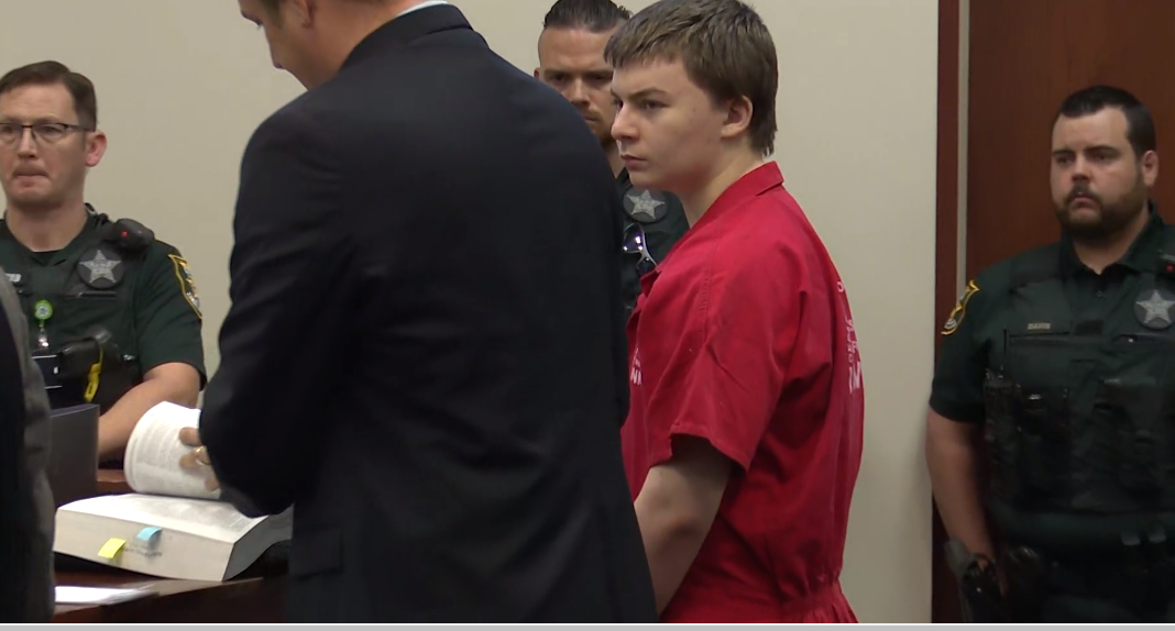 Aiden Fucci, in red jail jumpsuit, and one of his attorneys, Craig Atack, listen to what the judge says will be allowed at the sentencing phase for the 16-year-old's murder conviction in the stabbing death of classmate Tristyn Bailey. They were in St. Johns County Circuit Court on Wednesday.