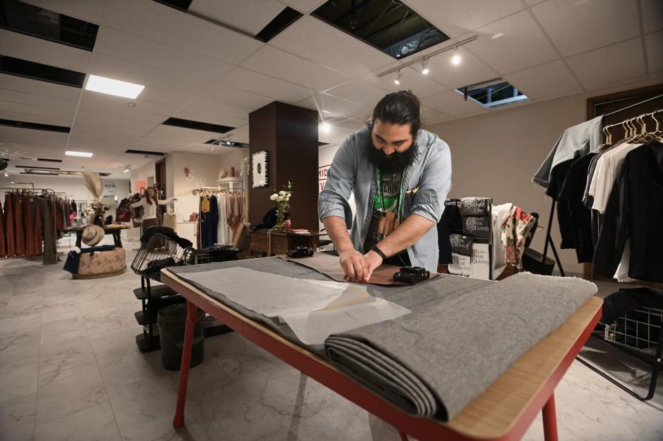 Middle Village Micro Market artist Oscar Peña of Black Rose Designs works on his clothing line, on Wednesday, May 8, 2024, in downtown Lansing.