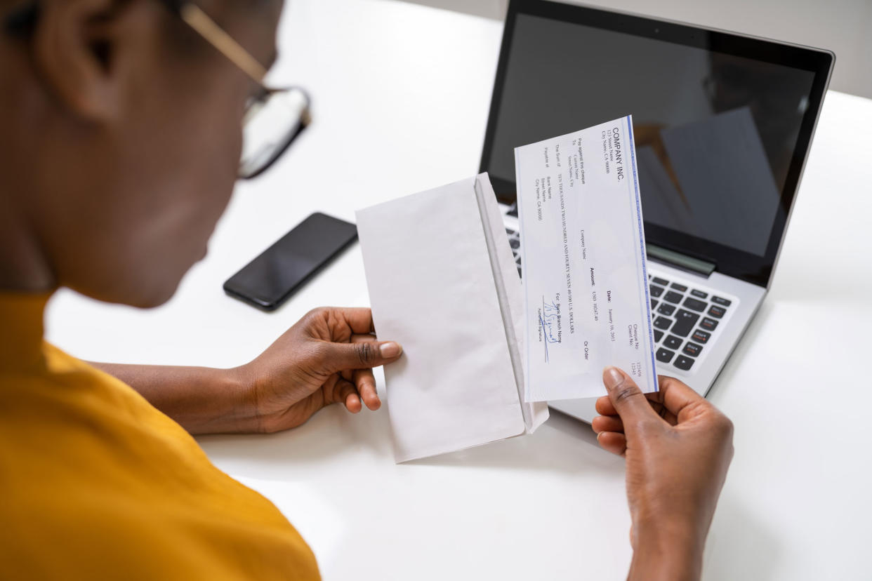 African-American woman holding paycheck