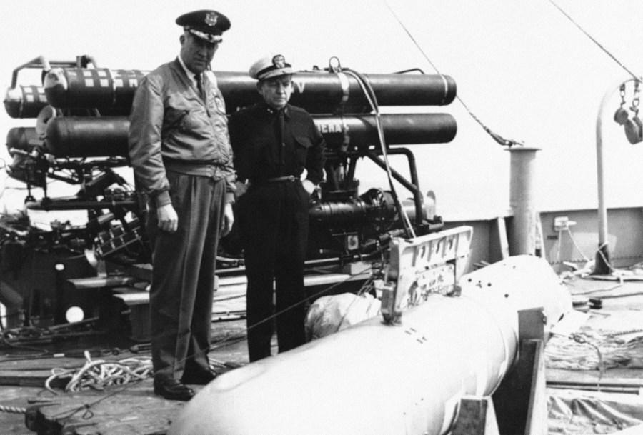 Maj. Gen. Delmar Wilson, left, USAF, and rear Adm. William S. Guest, USN, are at Palomares Beach, Spain on April 8, 1966, inspecting the H-Bomb that was recovered from the Mediterranean. Bomb had been lost since January, following a crash of two USAF planes. Behind them is the torpedo grapple device which was used to recover the weapon from 2,500 feet below the surface of the sea. (AP Photo)