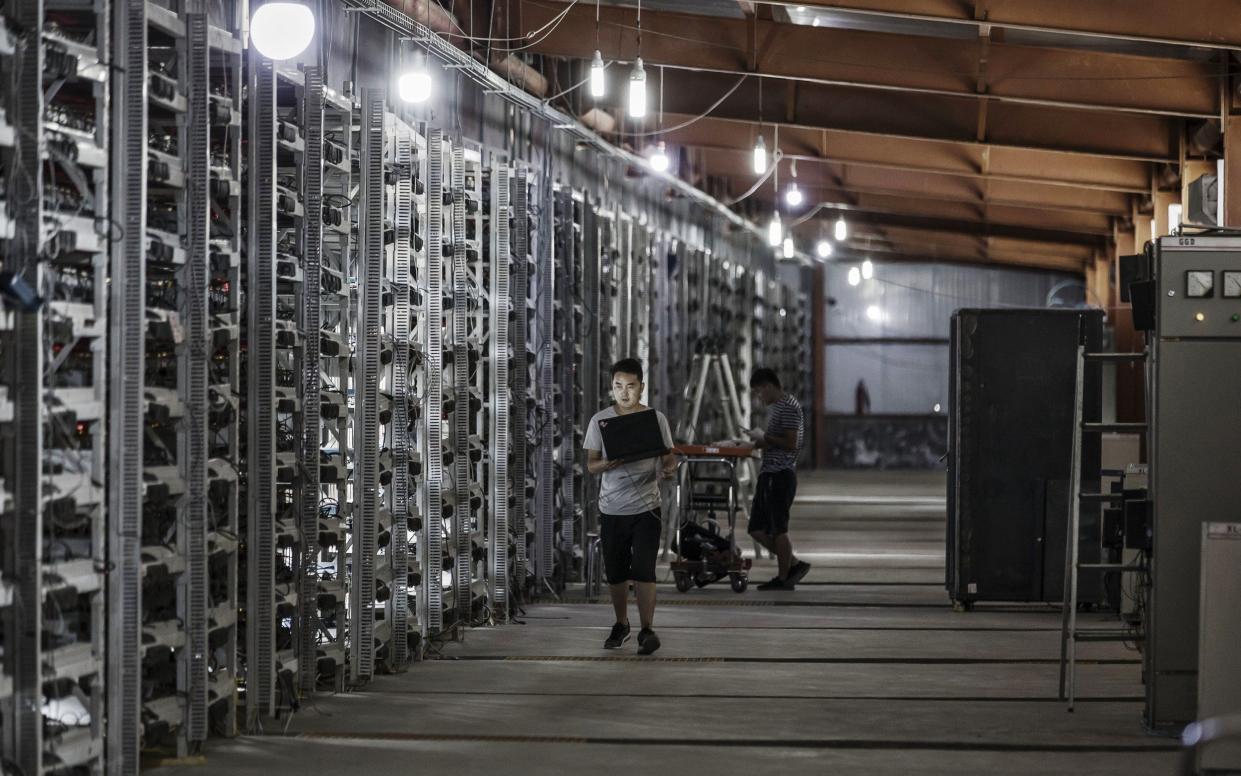 Technicians inspect bitcoin mining machines at a mining facility operated by Bitmain Technologies Ltd. in Ordos, Inner Mongolia, China - Qilai Shen /Bloomberg