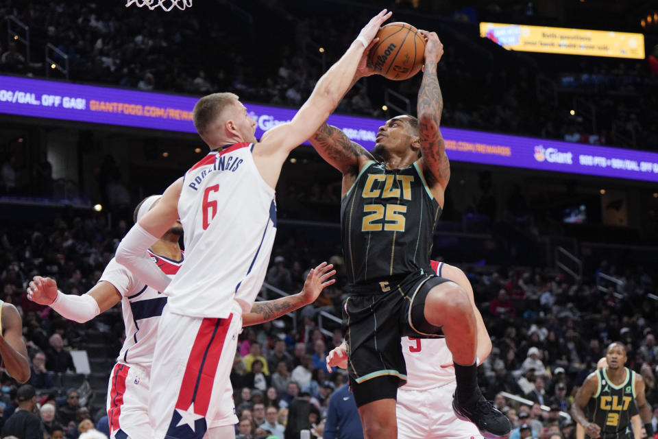 Washington Wizards center Kristaps Porzingis (6) defends as Charlotte Hornets forward P.J. Washington (25) shoots during the second half of an NBA basketball game Wednesday, Feb. 8, 2023, in Washington. (AP Photo/Jess Rapfogel)