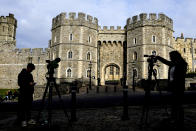 TV news crews report outside Windsor Castle, in Windsor, England, Friday, Oct. 22, 2021. Britain's Queen Elizabeth II spent a night in a hospital for checks this week after canceling an official trip to Northern Ireland on medical advice, Buckingham Palace said Thursday. The palace said the 95-year-old British monarch went to the private King Edward VII's Hospital in London on Wednesday for "preliminary investigations." It said she returned to her Windsor Castle home at lunchtime on Thursday, "and remains in good spirits."(AP Photo/Kirsty Wigglesworth)