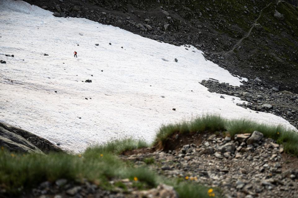 An alpinist walks on a snowfield on the path to the Boccalatte Hut in Courmayeur, Alps Region, north-western Italy, on August 5, 2021. - A melting glacier is posing challenges this summer for scientists on Italy's side of the Mont Blanc massif, where the risk of collapse in rising temperatures threatens the valley below. The Planpincieux glacier, at an altitude of about 2,700 metres (8,860 feet), hangs over the hamlet of Planpincieux, underneath the south face of the Grandes Jorasses within the Mont Blanc massif in Italy's picturesque northwest corner. (Photo by Marco Bertorello / AFP) (Photo by MARCO BERTORELLO/AFP via Getty Images)