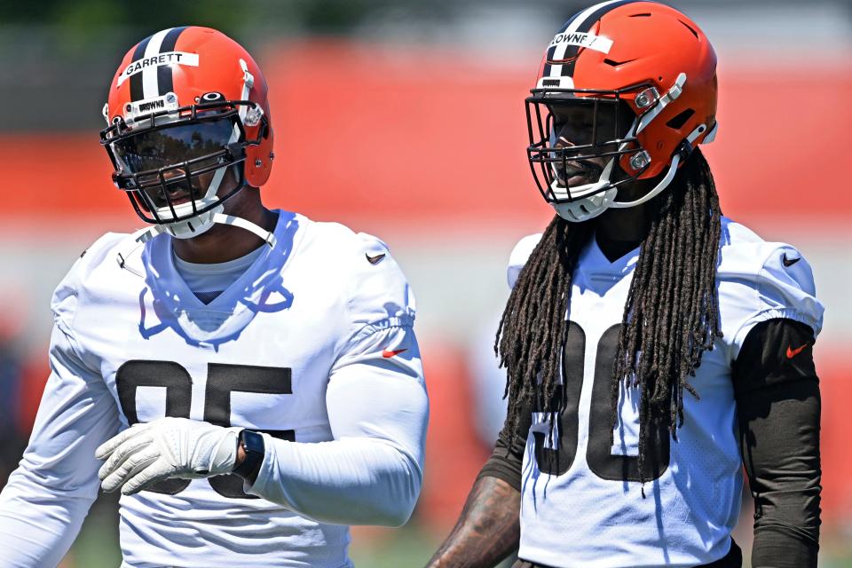 Browns defensive linemen Jadeveon Clowney, right, and Myles Garrett watch during practice in Berea,  June 17, 2021.