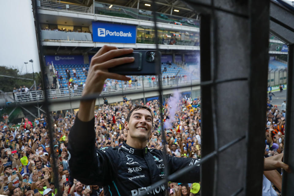 Mercedes driver George Russell, of Britain, takes a selfie with fans after winning the Brazilian Formula One Grand Prix, at the Interlagos race track in Sao Paulo, Brazil, on Nov. 13, 2022. (AP Photo/Marcelo Chello)