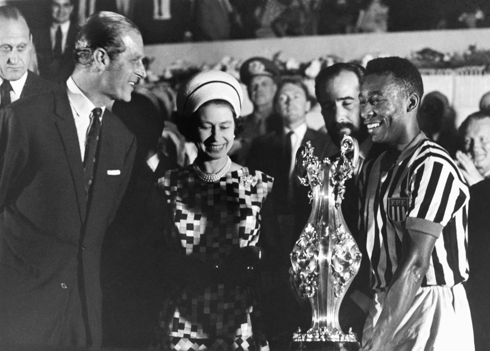 FILE - In this Nov. 10, 1968 file photo, Britain's Queen Elizabeth II with Prince Philip present a cup to soccer player Pele, right, at a stadium in Rio de Janeiro, Brazil, during a state tour of South America. Buckingham Palace officials say Prince Philip, the husband of Queen Elizabeth II, has died, it was announced on Friday, April 9, 2021. He was 99. Philip spent a month in hospital earlier this year before being released on March 16 to return to Windsor Castle. Philip, also known as the Duke of Edinburgh, married Elizabeth in 1947 and was the longest-serving consort in British history. (AP Photo/File)