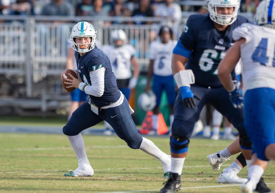 Quarterback Austin Reed (14) rolls out while looking for an open receiver during the Shorter vs UWF football game at Blue Wahoos Stadium in Pensacola on Saturday, Oct. 23, 2021.