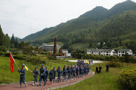 Participants dressed in replica red army uniforms march during a Communist team-building course extolling the spirit of the Long March, organised by the Revolutionary Tradition College, in the mountains outside Jinggangshan, Jiangxi province, China, September 14, 2017. REUTERS/Thomas Peter