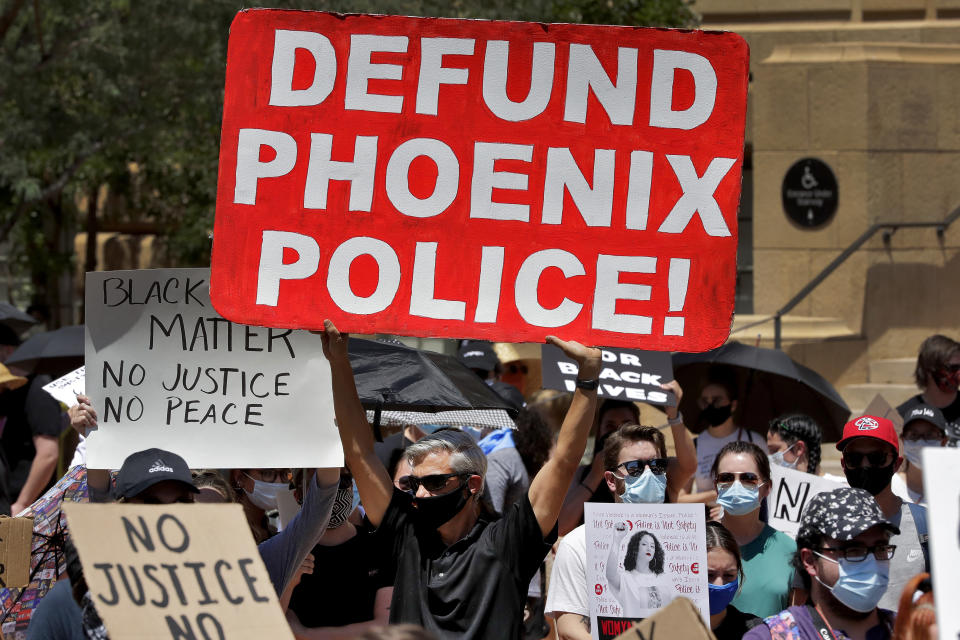 Protesters rally Wednesday, June 3, 2020, in Phoenix, demanding that the Phoenix City Council defund the Phoenix Police Department. The protest is a result of the death of George Floyd, a black man who died after being restrained by Minneapolis police officers on May 25. (AP Photo/Matt York)
