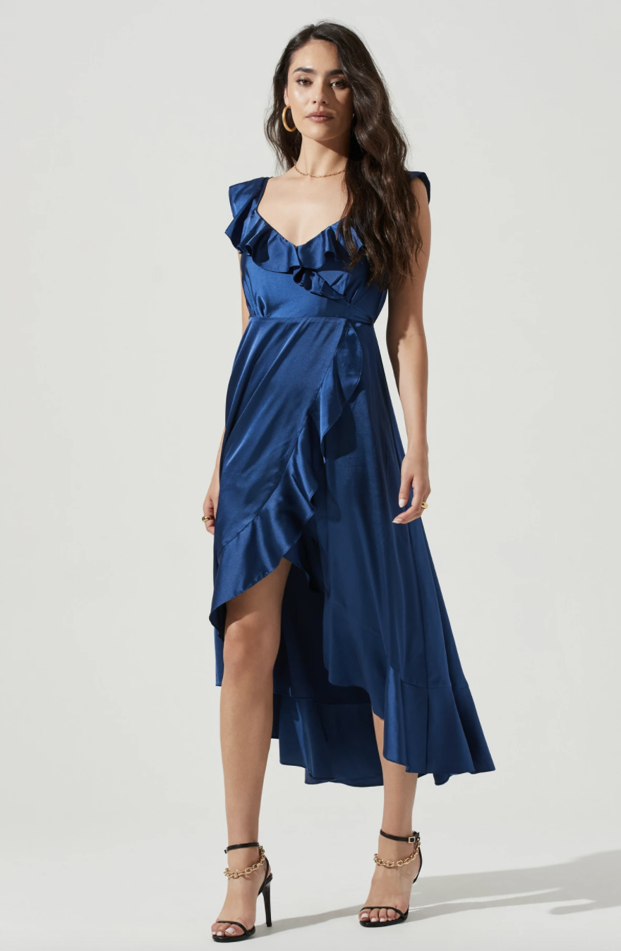 brunette model posing in navy blue silk midi dress with ruffles and thigh slit