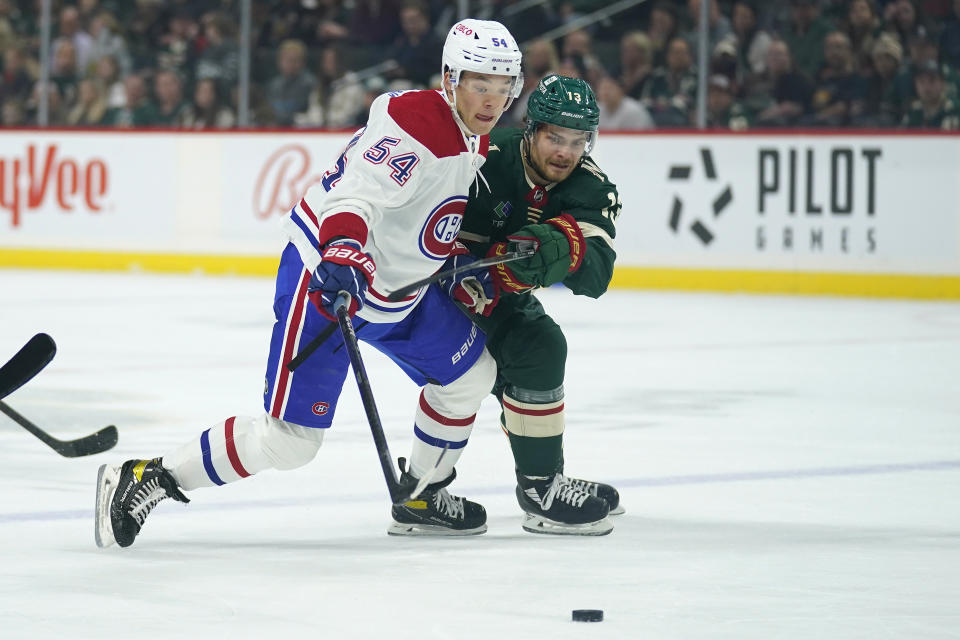 Montreal Canadiens defenseman Jordan Harris (54) and Minnesota Wild center Sam Steel (13) battle for the puck during the first period of an NHL hockey game Tuesday, Nov. 1, 2022, in St. Paul, Minn. (AP Photo/Abbie Parr)