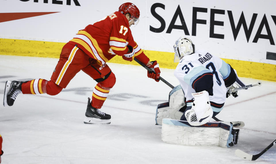 Seattle Kraken goalie Philipp Grubauer (31) comes out of the crease to block a shot by Calgary Flames forward Yegor Sharangovich (17) during second-period NHL hockey game action in Calgary, Alberta, Monday, March 4, 2024. (Jeff McIntosh/The Canadian Press via AP)