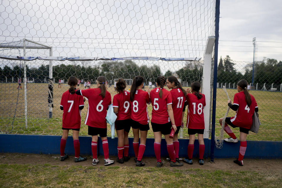 Candelaria Cabrera, a 12-year-old player with the Huracán de Chabas female team, (11), waits for the start of her team's soccer match against Alumni in Arequito, Santa Fe province, Argentina, Monday, June 19, 2023. “She goes happily to the pitch, thinks it is all normal, a part of her life,” said Rosana Noriega, Candelaria's mother. “She is happy because now she has many friends in soccer, they share her passion. She is not the strange kid. Now there are other girls who are strange too." (AP Photo/Natacha Pisarenko)